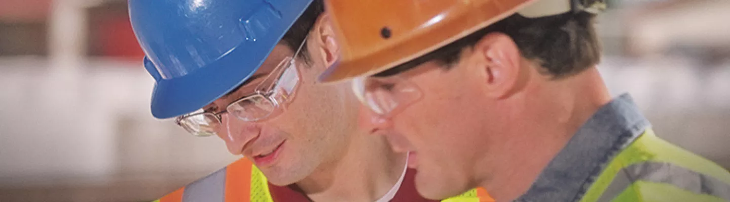 deux hommes portant un casque de sécurité sur un chantier de construction