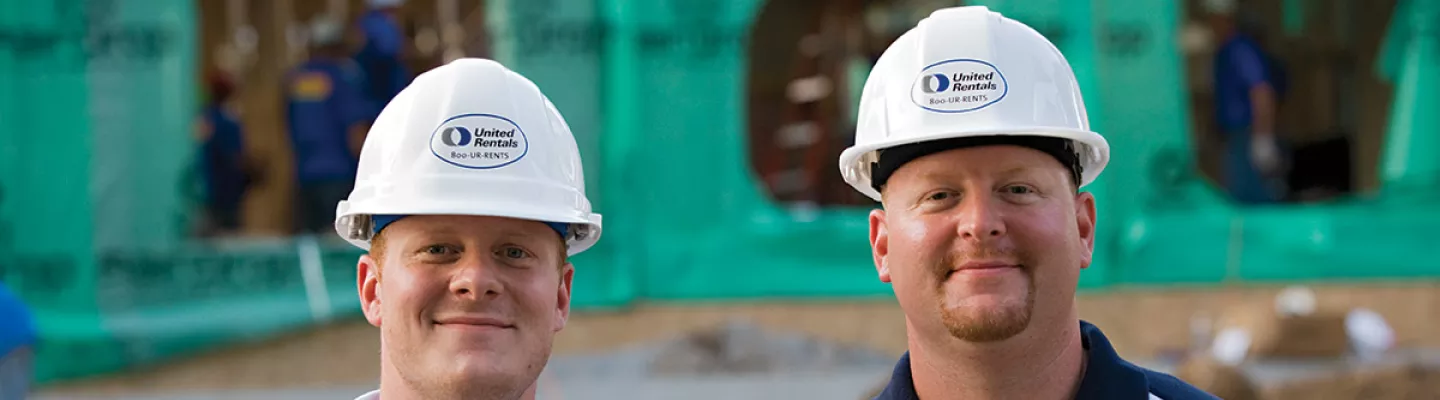 deux hommes portant un casque de sécurité sur un chantier de construction