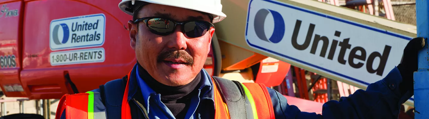 homme dans la construction avec tapis près de la nacelle élévatrice