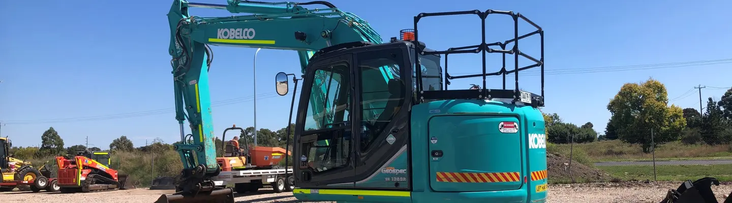 Équipement de construction positionné sur un site routier, utilisé pour installer ou entretenir des barrières de sécurité.