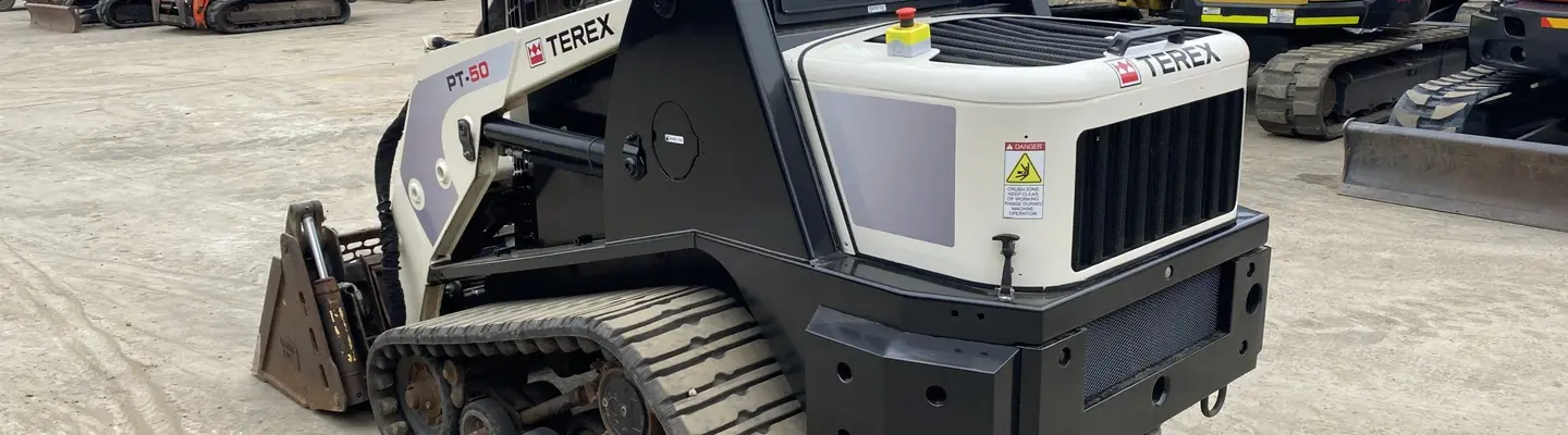 Une chargeuse à camion positionnée sur un chantier de construction, prête à être installée ou utilisée avec des machines lourdes.