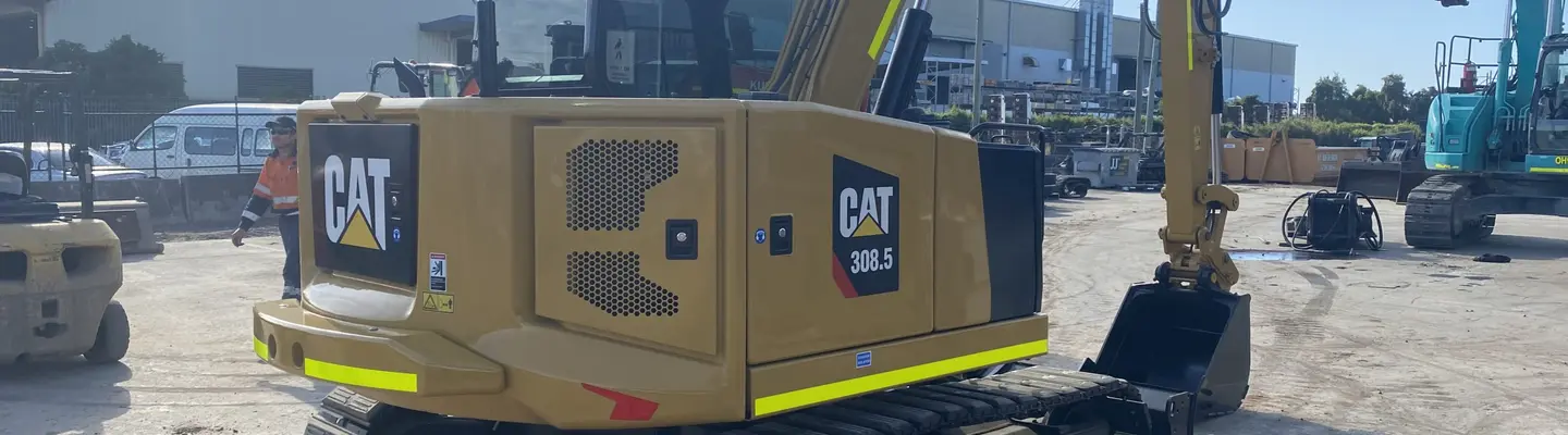 Homme debout à côté d’excavatrices sur un chantier de construction, supervisant les travaux liés à la barrière de sécurité ou à l’installation de rails.