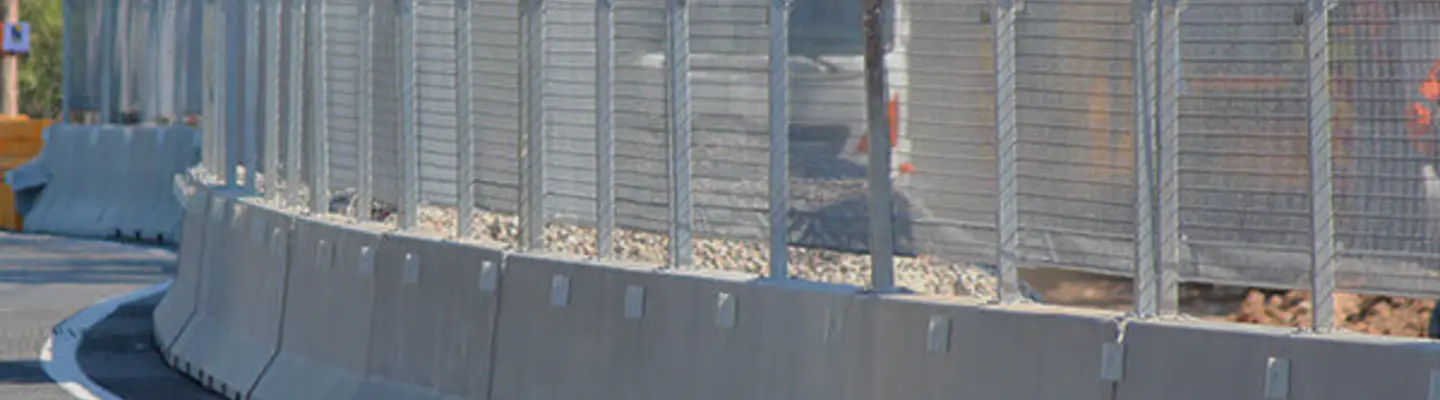 Barrières de sécurité barricadant une zone de construction routière pour protéger les travailleurs et guider la circulation des véhicules en toute sécurité autour du site.