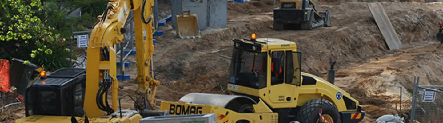 Différents types d’équipement de construction utilisés sur un site, soutenant des tâches comme l’excavation, le levage et l’installation de barrières.