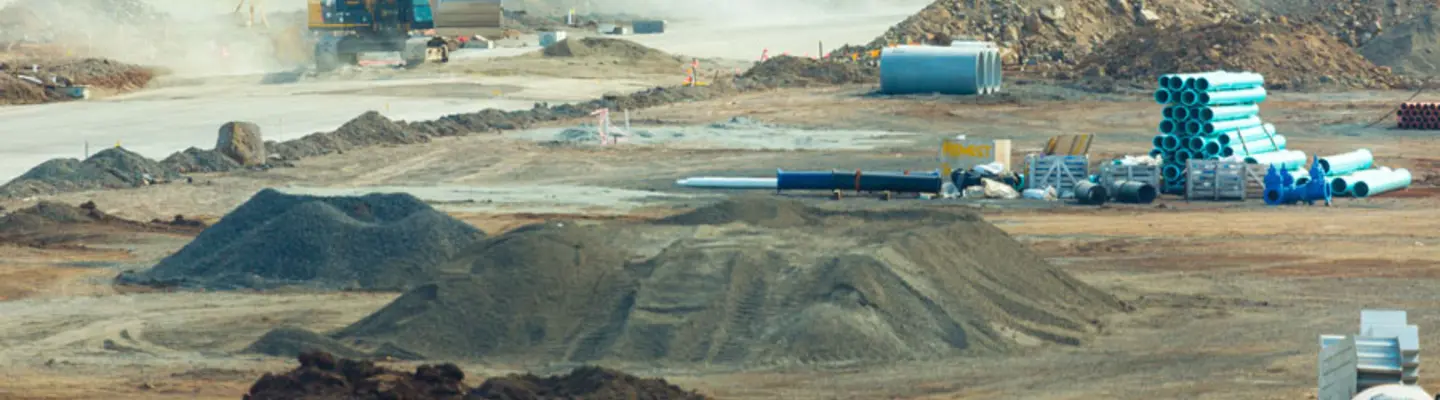 Divers types de barrières et de clôtures installées sur un chantier pour assurer la sécurité et contrôler l’accès autour des zones de construction.