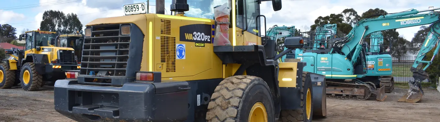 Divers équipements de location soigneusement disposés à l’extérieur, y compris des outils de construction et des machines prêtes à être utilisées par le client.
