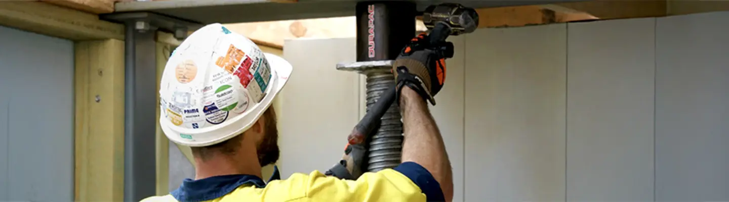 Homme installant un vérin hydraulique