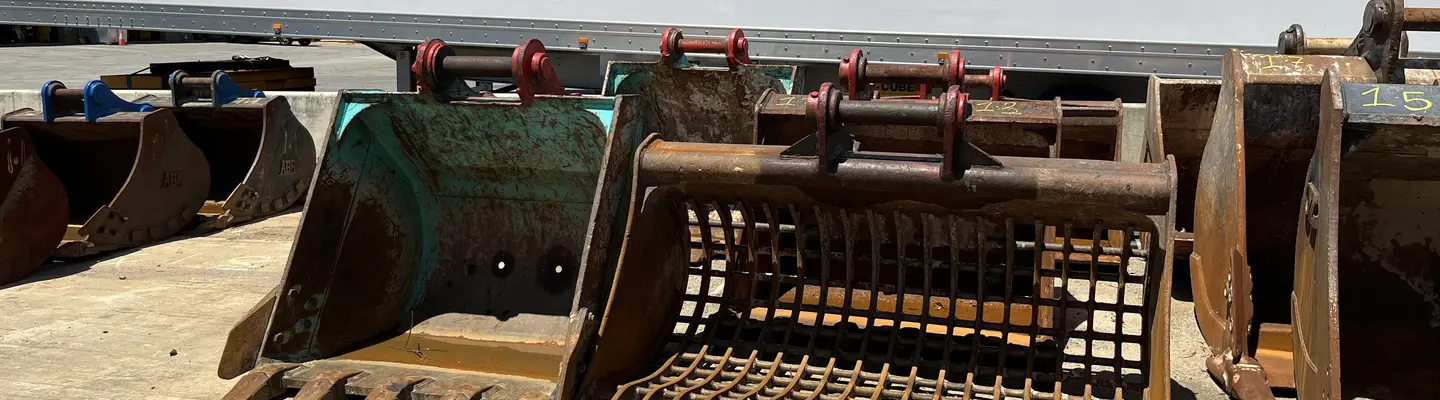 Godet de tamis - Un godet de tamis, utilisé pour le tri et le scellement des matériaux. Multi-processeur/pulvérisateur - Multi-processeur, ou également connu sous le nom de pulvérisateur, en action, monté sur une excavatrice entre des poignées de tri rotatives. 
