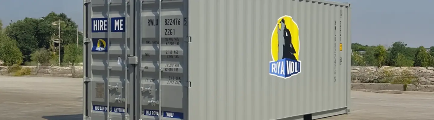 Un conteneur d’expédition gris de 6 mètres avec la marque Royal Wolf placé dans un cadre industriel extérieur.