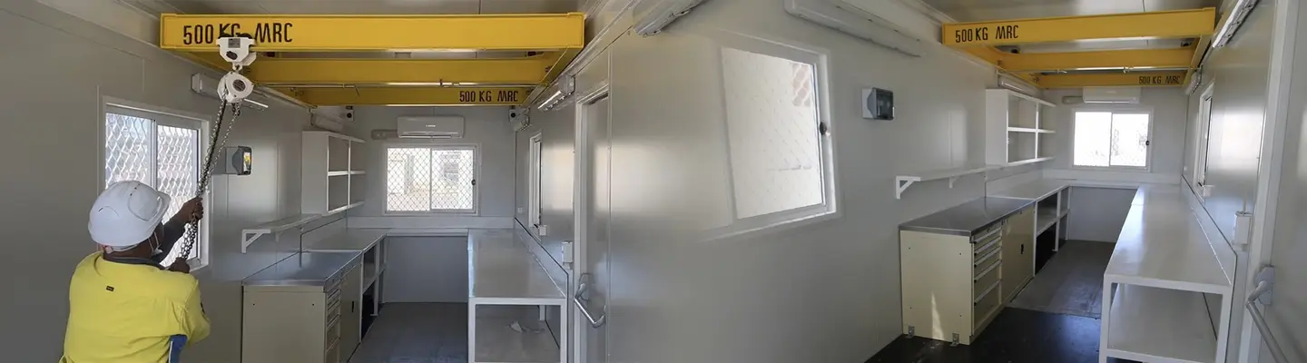 Conteneur d’expédition mobile converti en salle fonctionnelle, présentant un espace de vie ou de travail portatif et modulaire.