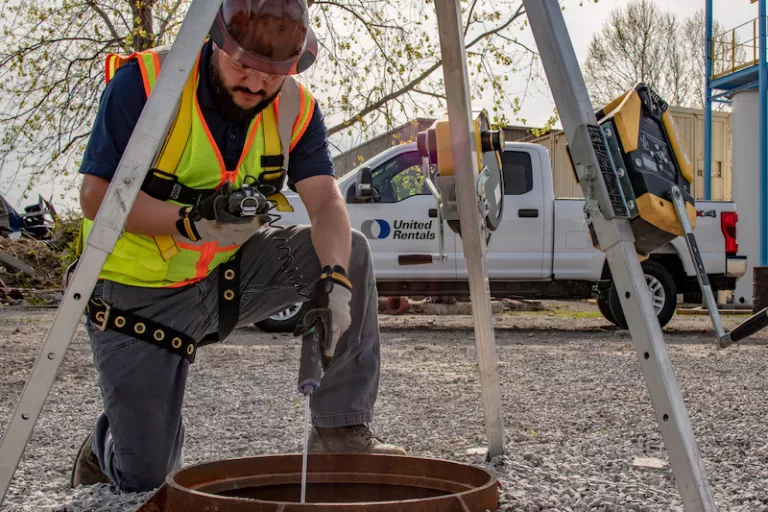 Ouvrier de construction utilisant de l’équipement de sécurité des tranchées dans un trou d’homme