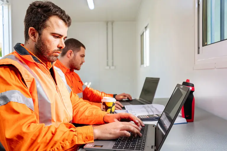 Homme dans un conteneur de stockage mobile travaillant sur un ordinateur