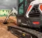 Mini-excavatrice BOBCAT noire et blanche avec balancement réduit de l’arrière