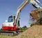Mini-excavatrice TAKEUCHI blanche, rouge et grise de 3,5 à 3,5 tonnes