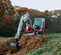 Mini-excavatrice Takeuchi rouge et blanche avec balancement réduit de l’arrière