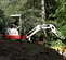 Mini-excavatrice TAKEUCHI rouge, blanche et grise de 3 000 à 3 999 lb, zéro balancement de l’arrière