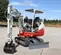 Mini-excavatrice Takeuchi rouge et blanche avec balancement réduit de l’arrière