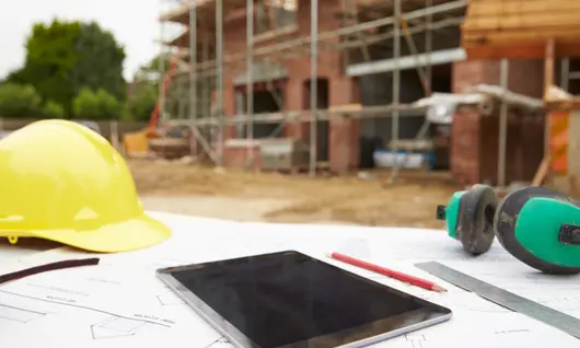 tablette et casque de sécurité sur un chantier de construction à l’extérieur