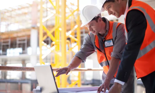 hommes travaillant sur un ordinateur sur le chantier