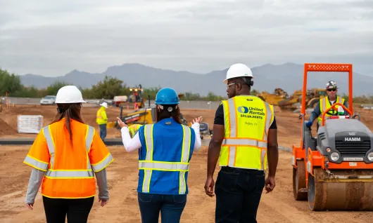 3 personnes sur le chantier se déplaçant vers l’équipement
