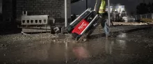 Worker pulling a light tower in the rain