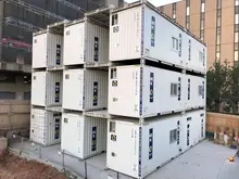 Multiple stacks of shipping containers arranged in a storage yard, ready for transport or repurposing.