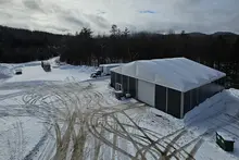 Grande tente de chantier installée dans un environnement extérieur enneigé, mettant en valeur sa structure robuste, son revêtement durable et son environnement climatisé.